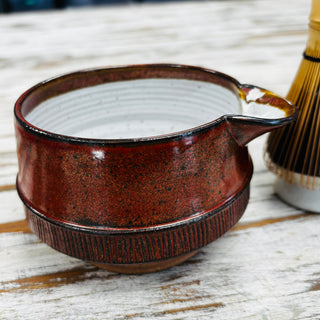 Red matcha ceramic bowl on a wooden surface