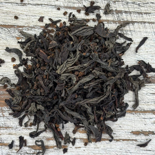Dry black tea leaves on a wooden surface