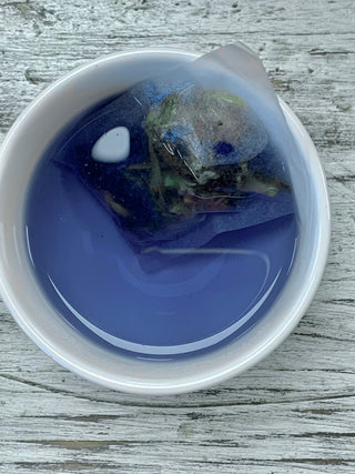 a white cup with beautiful blue tea and a tea bag. Blue Jay